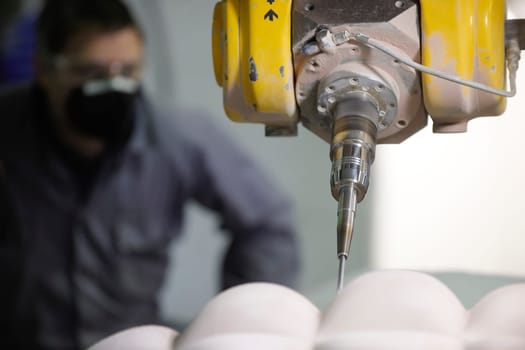 worker controlling a multi axis milling machine