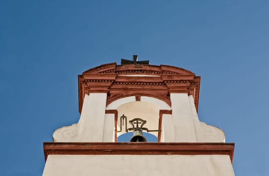 Red baroque whitewashed belfry over blue sky, Cordoba, Spain