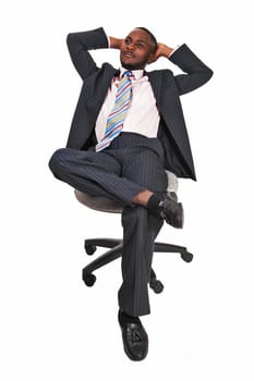 A handsome black man sitting on a chair, his legs crossed and leaning back.and relaxing for white background..