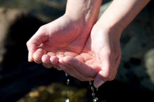 Woman hands playing with natural water