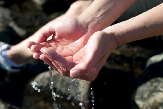 Woman hands playing with natural water