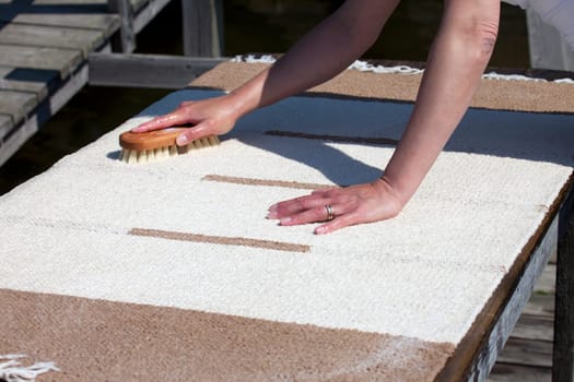 Scrubbing carpet on the dock