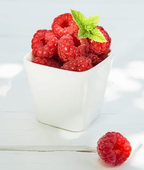 Ceramic container filled with fresh ripe raspberries for a delicious healthy snack full of vitamins and antioxidants