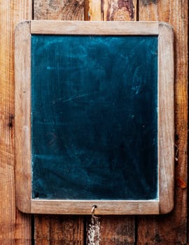 Vintage style wood framed chalkboard over old wood background. Space for insertion of your own text.