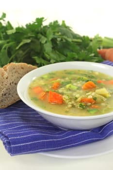 a white bowl of colorful pearl barley soup