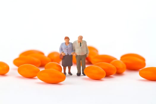 Senior couple with pills on light background