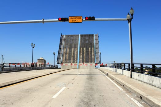 FORT LAUDERDALE, FLORIDA - MARCH 30, 2013: Red stop lights on the East Las Olas Boulevard drawbridge raised over the Atlantic Intracoastal waterway with a bright blue sky winter in the background.