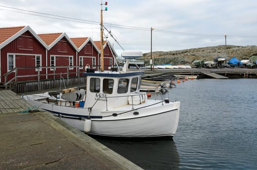 lonely small fishing boat in the harbor on a winter Klädesholmen