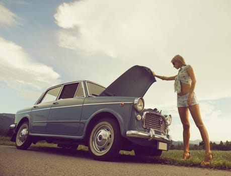 Young sexy woman with her broken car.