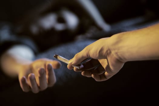Close up of two young adults smoking a joint