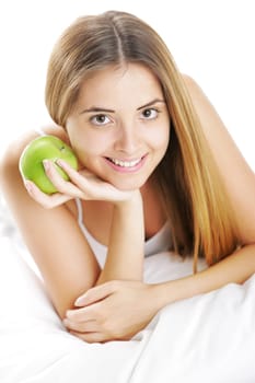 Smiling Young Woman Holding Apple in Bed