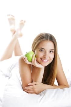 Smiling Young Woman Holding Apple in Bed