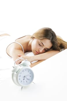 A young lady sleeping on the background with a clock on the foreground.