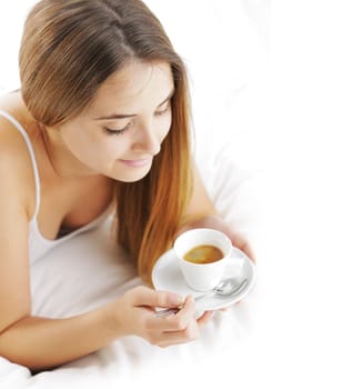 Beautiful young woman in bed drinking cofee in the morning.