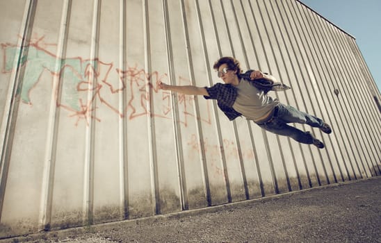 Young man feels like a superhero, flying free.