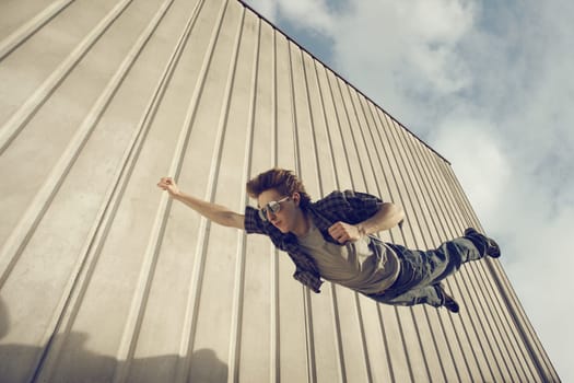 A young man feels like a superhero, flying free.
