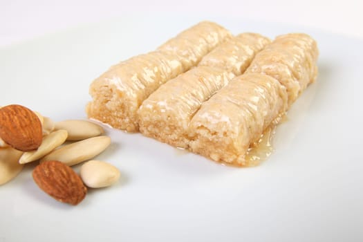 Typical turkish dessert durum with almonds on white background