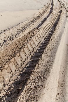 Industrial car tire traces on sand background
