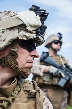 US marine half-turned to the camera. His brother-soldier looking in the same direction