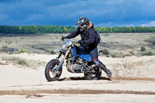 Enduro bike rider driving across the desert
