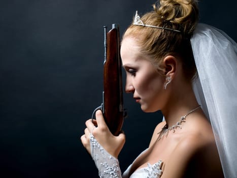 beauty young bride in white dress holding the old gun
