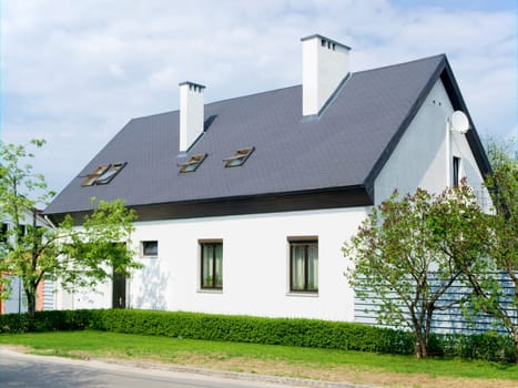 Modern town house with satellite dish on a summer day