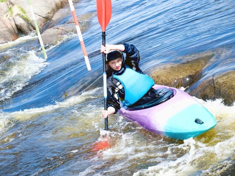 a shot of the female kayaker on the rough water