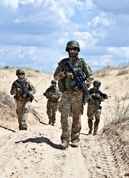 Squad of soldiers patrolling across the desert