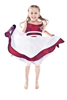 Laughing little girl in red and white dress jumping and lifting up her skirt