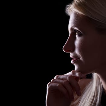 Backlit portrait of caucasian woman profile on black background