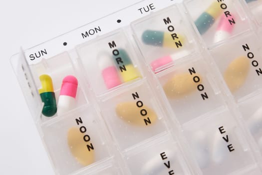 Different types of pills in a weekly dosage container
