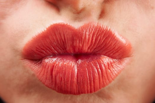 close up of womans pouting lips with red lipstick