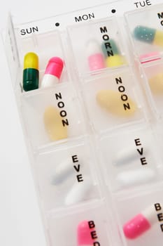 Different types of pills in a weekly dosage container