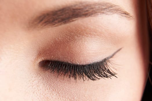 close up of womans brown eye lid with false eye lashes