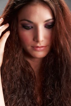 Portrait of beautiful young woman with make-up on grey background