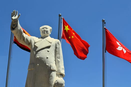 A Statue of China's former Chairman Mao Zedong with Chinese flagin the city of Lijang, China
