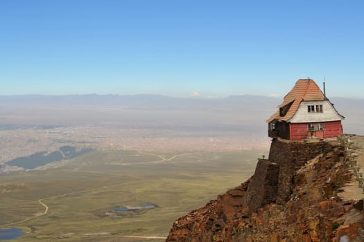 A house sitting high on the edge of rocky cliffs overlooking La Paz at the world's highest ski resort Chacaltaya, Bolivia, South America
