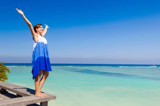 Beautiful woman with arms open enjoying the summer