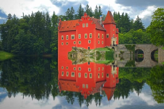 Reflection of the red castle on the lake. State castle Cervena Lhota, Czech Republic)