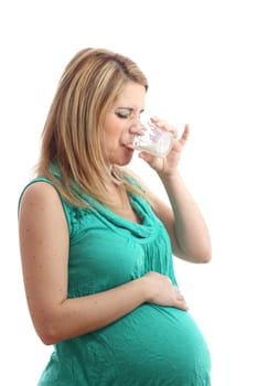 A pregnant woman is drinking a glass of milk and she doesn't like it!
