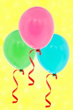 Colorful inflatable balloons flying on the yellow background