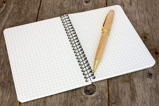 Notebook with a pen on the old wooden floor