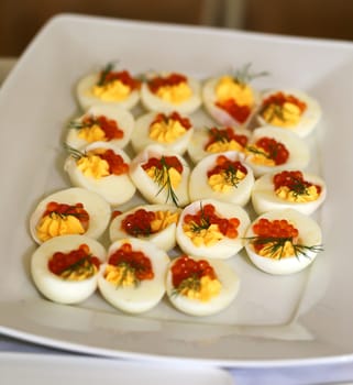 Dish with red caviar in a chicken egg