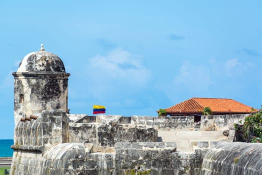 Defensive wall surrounding the historic center of Colombia with a Colombian flag waving in the breeze