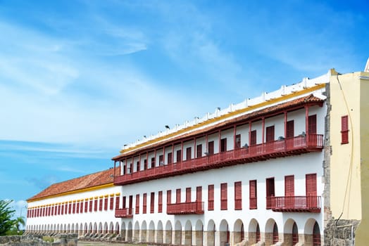Facade of a white colonial buildings with red balconies in the historic center of Cartagena, Colombia