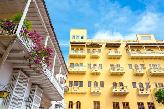 Yellow colonial building next to a white colonial balcony in the historic center of Cartagena, Colombia