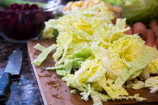 Chopped savoy cabbage on cutting board with knife