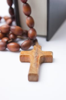 The Holy Bible with a wooden cross on top of it.
