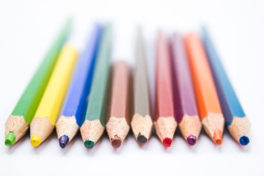 Different color pencils arranged on a white background.