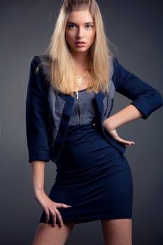 Beautiful and attractive woman posing on studio over a dark gray background